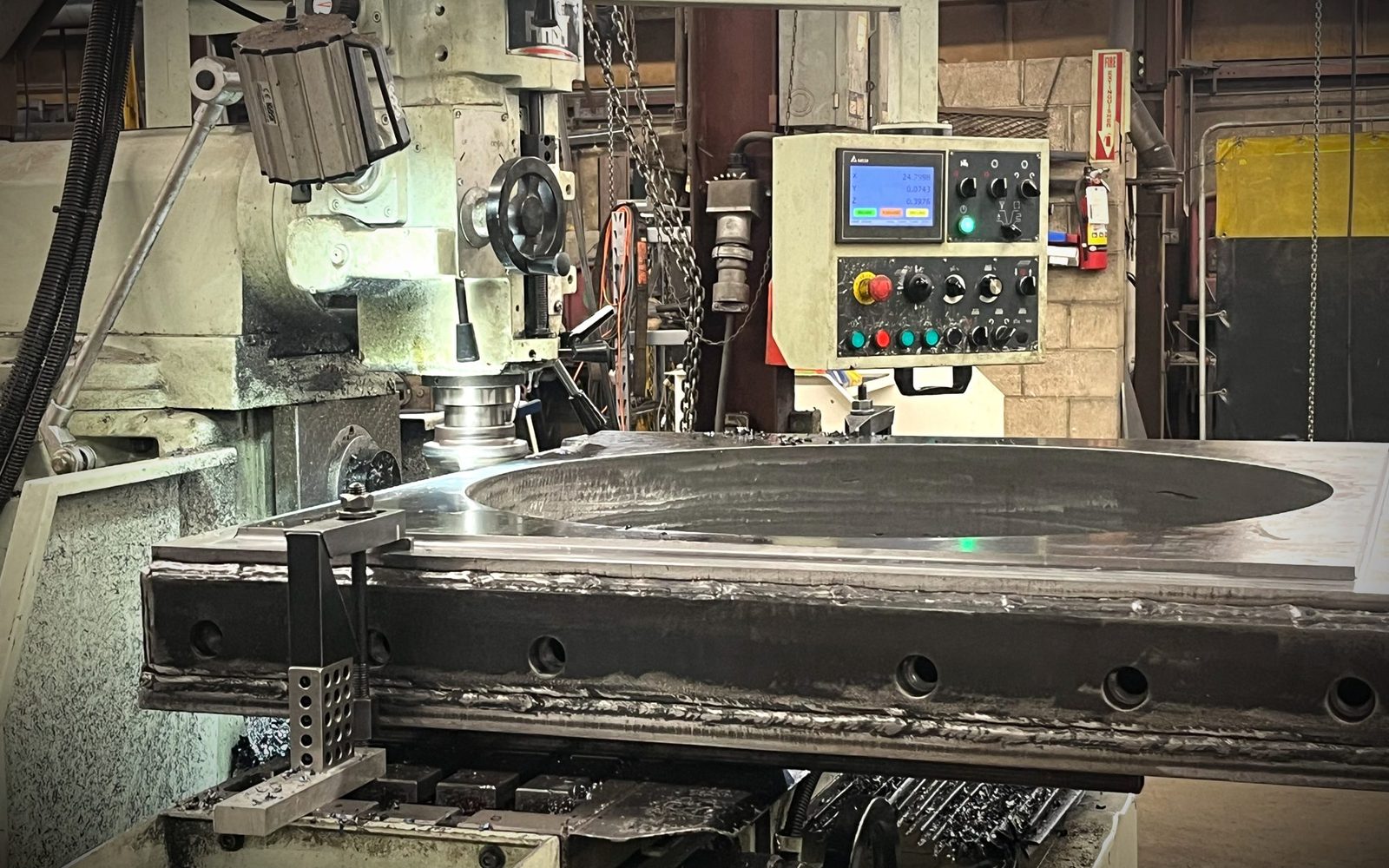 Large round steel plate set up on the milling machine at Dan's Welding in Burlington, being machined flat after fabrication
